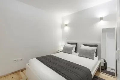 a white bedroom with a large bed with two pillows at BO - Almada in Porto