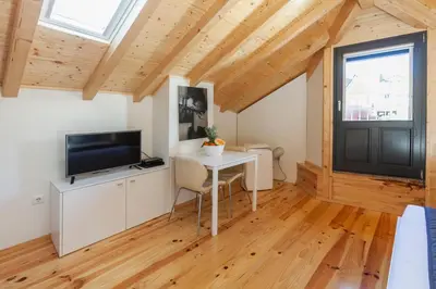 a room with a table and a tv and a window at BO - Almada in Porto