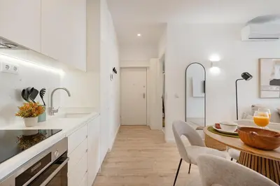 a kitchen with white cabinets and a sink with utensils at The Soft Escape @ BoaVista Flats in Porto