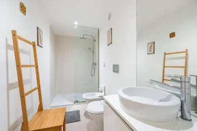 a white bathroom with a sink and a toilet at GuestReady - Dolce experience in Porto in Porto