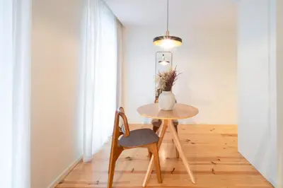 a table and a chair in a room with a vase at Luxurious Studio Retreat in Porto by LovelyStay in Porto