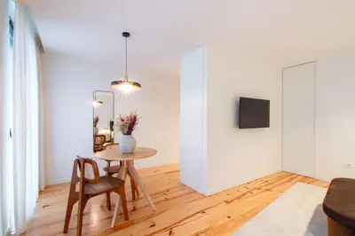 a living room with a table and chairs and a tv at Luxurious Studio Retreat in Porto by LovelyStay in Porto