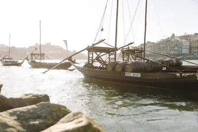 a boat with barrels on it in the water at Oporto Welcome Apartments - Ribeira Negra in Porto