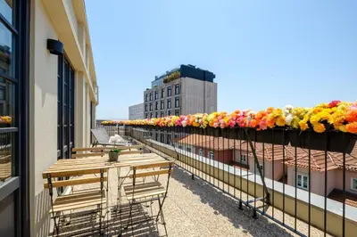 a balcony with benches and flowers on a building at Art Deco 42 Luxury 2BR Apartment Downtown Metro AC in Porto