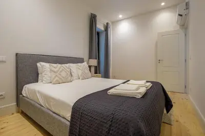 a bedroom with a bed with two towels on it at Art Deco 13 Luxury 2BR Apartment Downtown Metro AC in Porto