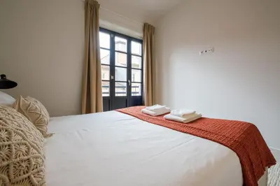 a bedroom with a bed with two towels on it at Art Deco 23 Luxury 2BR Apartment Downtown Metro AC in Porto