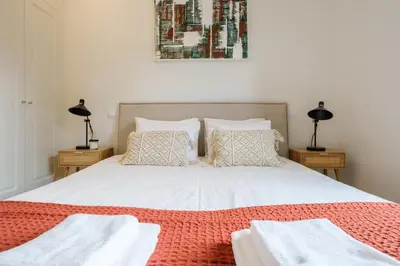 a bedroom with a white bed with two night stands at Art Deco 23 Luxury 2BR Apartment Downtown Metro AC in Porto