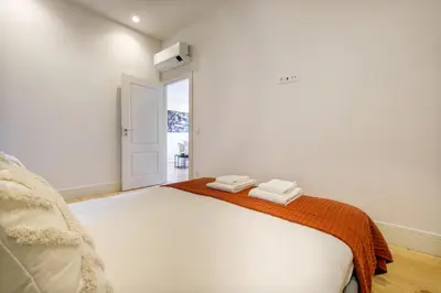 a white bedroom with a bed with two towels on it at Art Deco 33 Luxury 2BR Apartment Downtown Metro AC in Porto