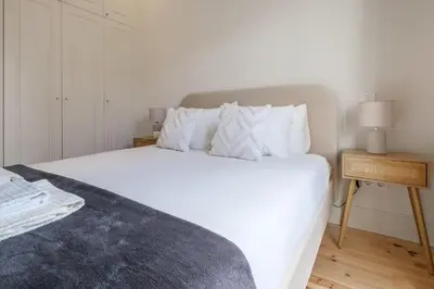 a bedroom with a large white bed with white pillows at Art Deco 22 Luxury 2BR Apartment Downtown Metro AC in Porto