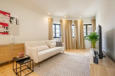 a living room with a white couch and a tv at Art Deco 22 Luxury 2BR Apartment Downtown Metro AC in Porto