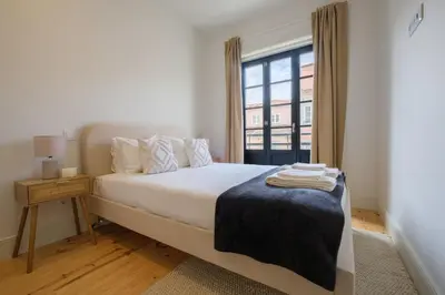 a white bedroom with a bed and a window at Art Deco 22 Luxury 2BR Apartment Downtown Metro AC in Porto