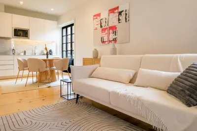 a living room with a white couch and a kitchen at Art Deco 22 Luxury 2BR Apartment Downtown Metro AC in Porto