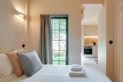 a bedroom with a white bed with a large window at Figueirôa Four Houses by DA'Home in Porto