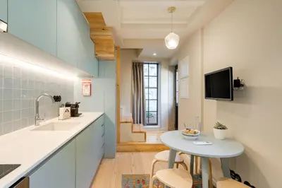 a kitchen with a table and a sink and a tv at Figueirôa Four Houses by DA'Home in Porto