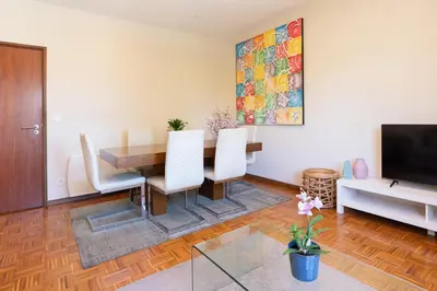 a dining room with a table and chairs and a tv at Bright & Spacious Flat by Host Wise in Porto