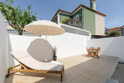 a dining room with a table and a tv at HostWise - Traditional House with Terrace in Porto