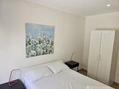a bedroom with a bed and a painting on the wall at Apartamento Camões in Porto