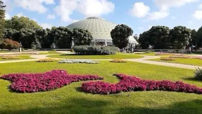 a park with flowers in the grass with a building at Crystal Palace Oporto Flat - With Two Bedrooms in Porto