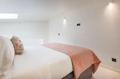 a bedroom with a bed in a white room at Minimalist Loft @ Terracotta Collection in Porto