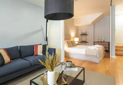 a living room with a blue couch and a bed at Porto Insight Apartments - Belomonte in Porto