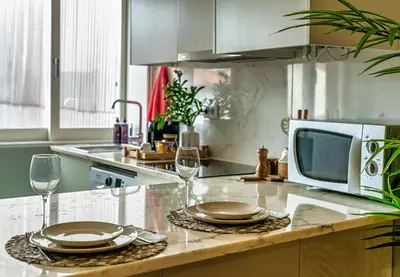 a kitchen with a microwave and two plates and wine glasses at Porto Insight Apartments - Belomonte in Porto