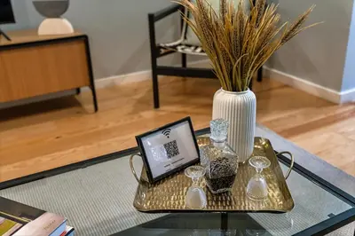 a glass table with a tablet and a vase on it at Porto Insight Apartments - Belomonte in Porto