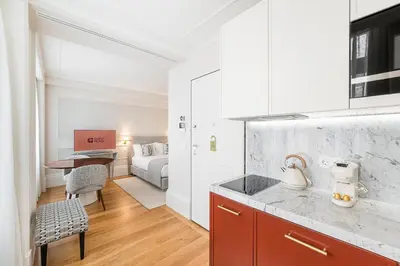 a kitchen with a counter top and a room with a bed at GuestReady - Elisium Star in Porto