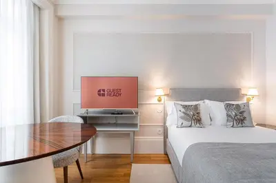 a bedroom with a bed and a table with a television at GuestReady - Elisium Star in Porto