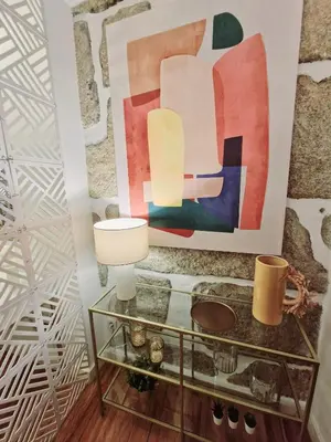 a table with a lamp and a painting on the wall at OPO Ribeira I in Porto