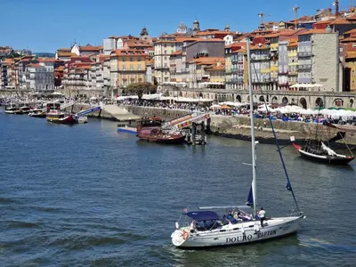 a sailboat in a river with a city in the background at OPO Ribeira II in Porto