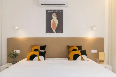 a bedroom with a large bed with yellow and black pillows at OPO Ribeira II in Porto