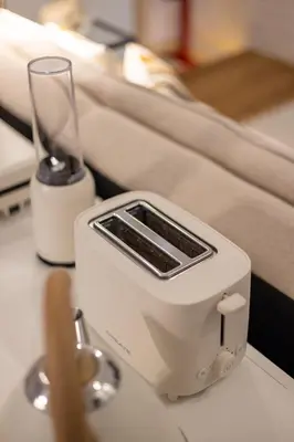 a white toaster sitting on a table next to a glass at OPO Ribeira II in Porto