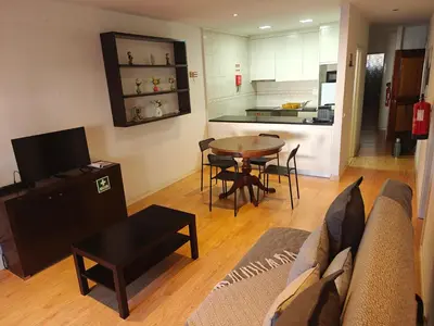 a living room with a couch and a table and a kitchen at Ap Recanto do Pilar 5 min Ponte Luis in Vila Nova de Gaia