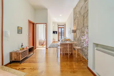 a kitchen and dining room with a table and a stone wall at HostWise - Stylish Flat with Balcony in Porto