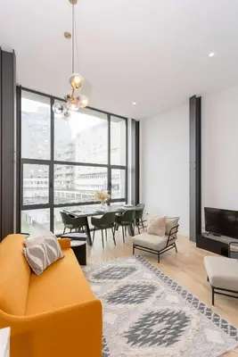 a living room with a yellow couch and a table at Liiiving in Porto - Crystal Luxury Apartment in Porto