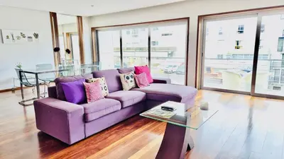 a purple couch in a living room with a glass table at VER Torrinha -Porto in Porto