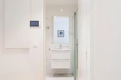 a white bathroom with a sink and a mirror at Studio w/ Terrace, Pool & Gym | Antas by Host Wise in Porto