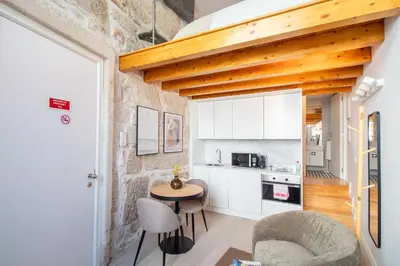 a kitchen with a table and chairs in a room at Cozy Mezzanine Hideaway w AC by LovelyStay in Porto