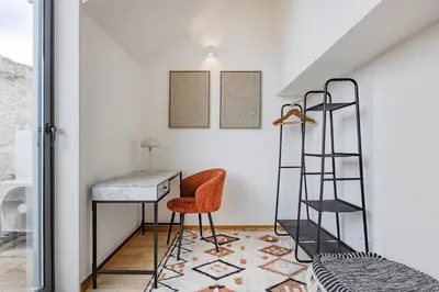 a bedroom with a desk and a chair and a ladder at Saldanha Boho Duplex in Porto