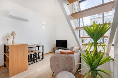 a living room with white cabinets and a table at Saldanha Boho Duplex in Porto