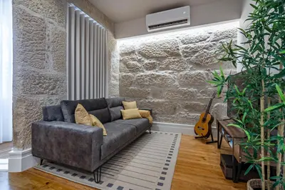 a living room with a couch and a guitar at ApartmentsPorto - Porto Dukes House in Porto