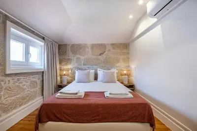 a bedroom with a large bed with a red blanket at ApartmentsPorto - Porto Dukes House in Porto