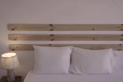 a bed with white pillows and a wooden headboard at Light & Airy Historic Centre House with Balconies in Porto