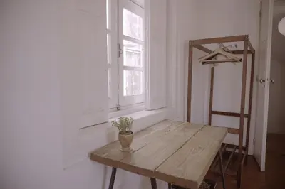 a wooden table in a room with a window at Light & Airy Historic Centre House with Balconies in Porto