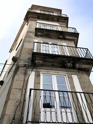 a tall building with a balcony on top of it at Light & Airy Historic Centre House with Balconies in Porto