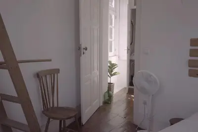 a room with a door and a chair and a fan at Light & Airy Historic Centre House with Balconies in Porto