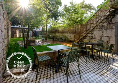 a patio with tables and chairs in a yard at Malmerendas Boutique Lodging in Porto