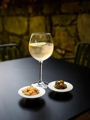 a glass of wine and plates of nuts on a table at Malmerendas Boutique Lodging in Porto