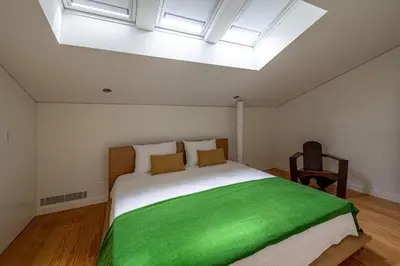 a bedroom with a large bed with a green blanket at 5daMaria - Porto Center in Porto