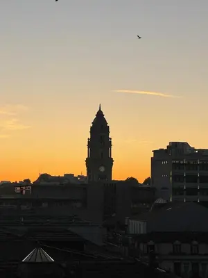 a building with a clock tower at sunset at 5daMaria - Porto Center in Porto